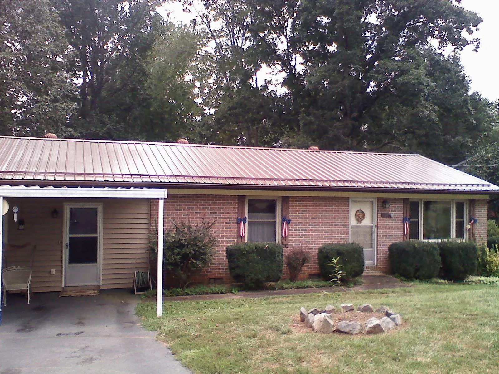 Bronze metal roof and carport on a brick ranch home — Roof Repair work by our crew in Seal Rock